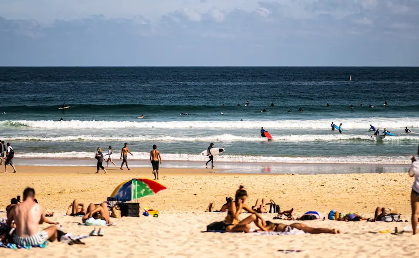 Noosa Main Beach on a clear spring morning with swimmers near the patrolled beach area