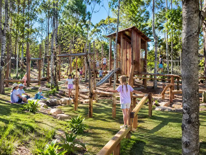 Children playing on a timber adventure playground near Noosa during a family holiday.