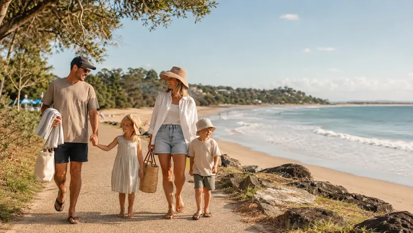 Family walking near Noosa Main Beach in warm autumn light during a Noosa holiday with kids.